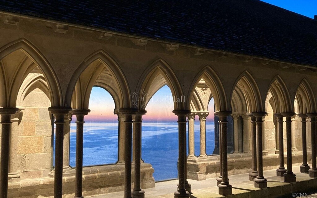 Le Cloître de l’abbaye du Mont-Saint-Michel en nocturne, avec une vue spectaculaire sur la mer.